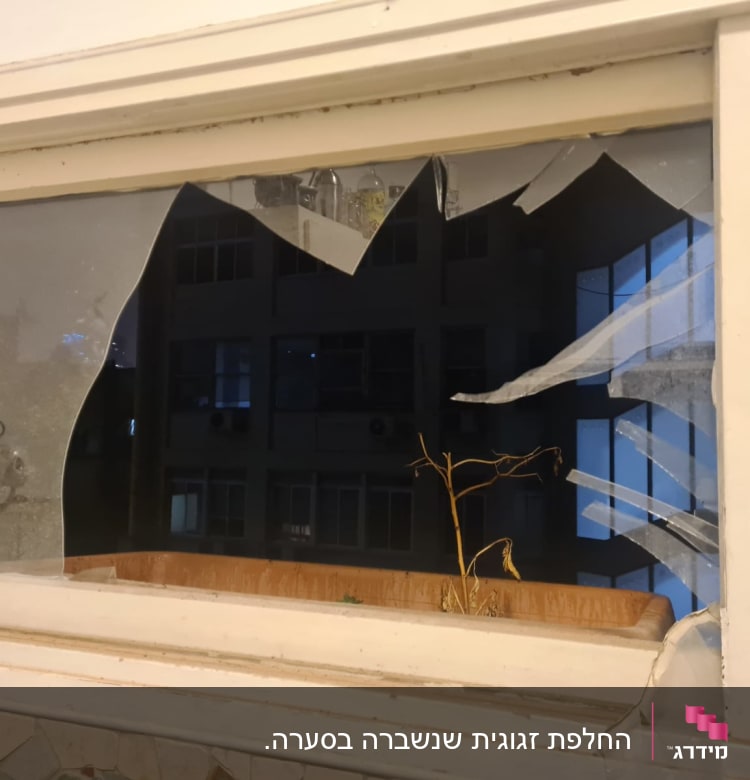 חלון זכוכית שבור עם שברים חדים מסביב